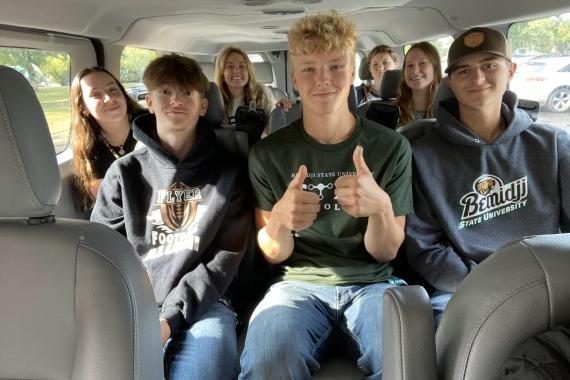 STEM scholars are enjoying a trip in the van to their next event. Thumbs up.